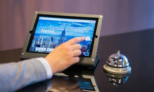 Hotel guest checking in using a tablet at the front desk